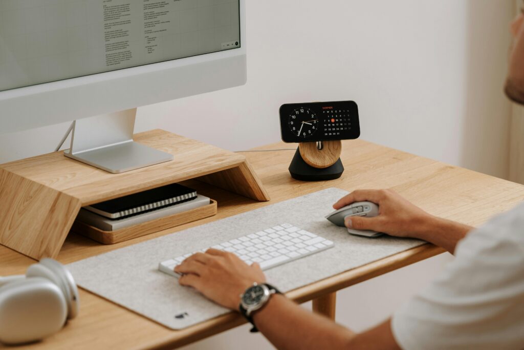 Hizmetlerimiz A clean and modern desk setup featuring a computer, clock, and accessories in a home office.